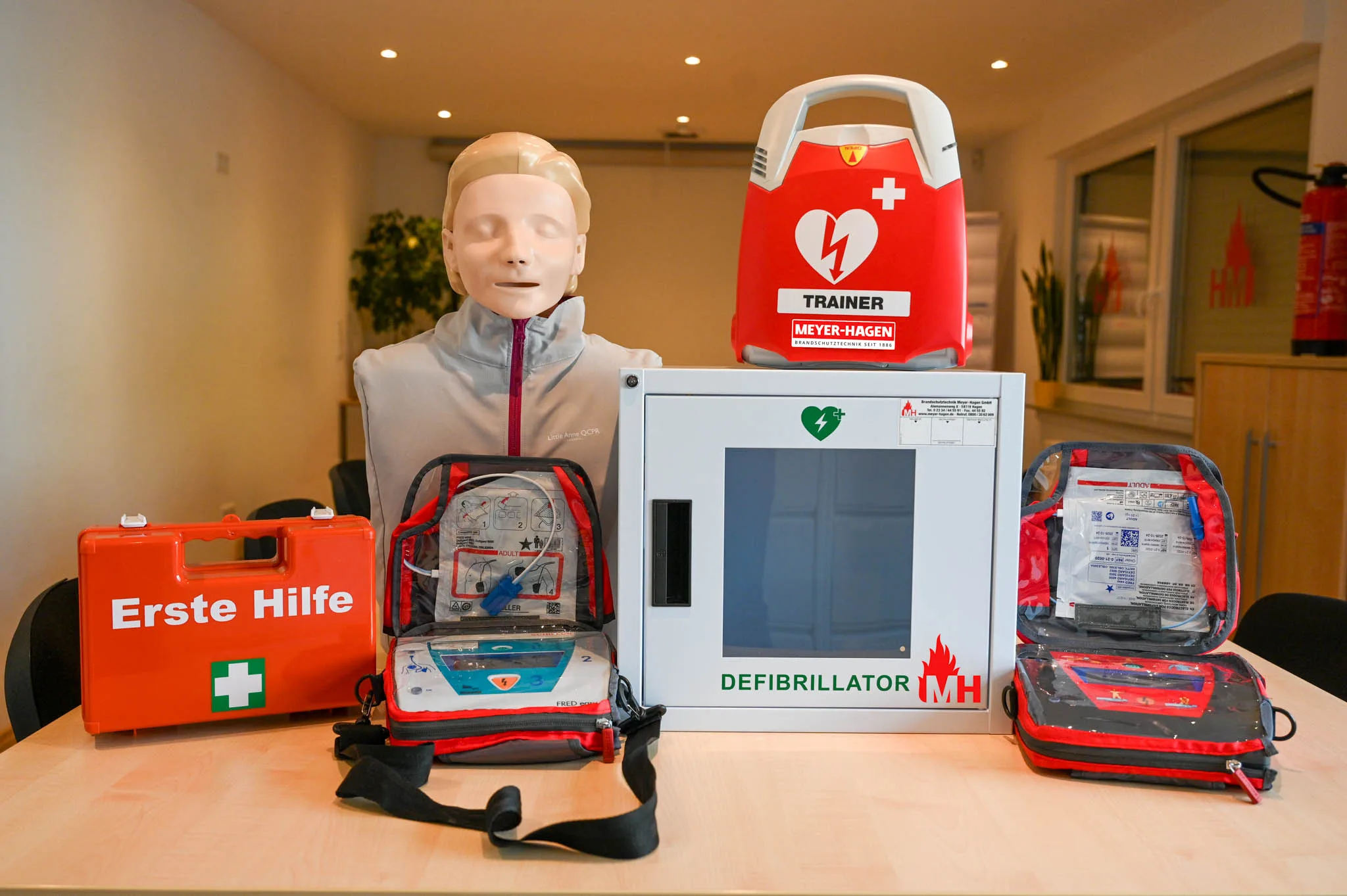 Ein AED incl. Puppe, zwei Geräte, ein Trainingsgerät und ein Erste-Hilfe Kasten sowie ein Wandkasten für einen AED